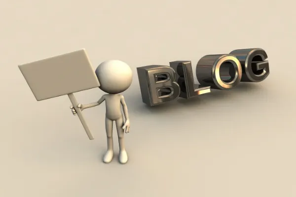 A 3D-rendered character, resembling a simple human figure, holds up a blank white sign. To the right of the figure, the word "BLOG" is spelled out in large, shiny, metallic, three-dimensional letters, creating a scene that metaphorically represents someone using a blog to make a statement or convey a message.